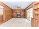 Cozy living room featuring wood paneling, a brick fireplace, built-in shelving, and sliding glass doors at 1152 Old Coach Rd, Stone Mountain, GA 30083