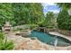 A backyard oasis featuring a stone-accented pool, spa, and outdoor fireplace with a waterfall feature at 2726 Mabry Ne Rd, Atlanta, GA 30319