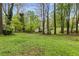 Serene backyard with mature trees, a storage shed, and a lush green lawn, perfect for relaxation at 3450 Brookhill Cir, Marietta, GA 30062