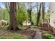 Lush backyard featuring mature trees, stone pathway, and a storage shed with a wooden deck at 3450 Brookhill Cir, Marietta, GA 30062