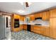 Well-lit kitchen featuring honey oak cabinetry, black appliances, and durable flooring at 3450 Brookhill Cir, Marietta, GA 30062