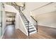 Bright foyer with hardwood floors, an open staircase and views of the kitchen with white cabinets at 8908 Brandy Rose, Douglasville, GA 30134