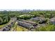An aerial view of townhomes with a city skyline backdrop, nestled among lush green trees and landscaping at 1129 Cordia Nw Ave, Atlanta, GA 30318