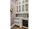 Chic butler's pantry features marble countertops, wine fridge, ice maker and custom white glass front cabinetry at 1129 Cordia Nw Ave, Atlanta, GA 30318