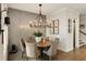 Dining area with designer chandelier and decorative wall paneling adjacent to entry with stairs at 1129 Cordia Nw Ave, Atlanta, GA 30318