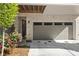 Two-car garage with gray door and brick exterior, alongside a garden with pink flowers at 1129 Cordia Nw Ave, Atlanta, GA 30318