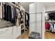 Spacious walk-in closet with custom shelving, hanging racks, drawers, and a plush gray ottoman seat at 1129 Cordia Nw Ave, Atlanta, GA 30318