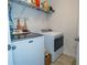 Bright laundry area featuring modern Maytag machines and ample shelving for supplies at 1809 Park Land Ln, Snellville, GA 30078