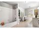This bright bathroom features white cabinets, a vanity, and a tub with white tiling at 3018 Bradshaw Club Dr, Woodstock, GA 30188