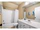Bright bathroom features a shower-tub combo with white tiling and a white vanity with a large mirror at 3018 Bradshaw Club Dr, Woodstock, GA 30188
