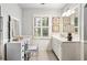 This bright bathroom boasts a large mirror, shutters on the window, and white wainscoting at 3018 Bradshaw Club Dr, Woodstock, GA 30188