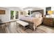 Spacious bedroom with double doors, plush bedding, and wood-look flooring at 3018 Bradshaw Club Dr, Woodstock, GA 30188