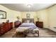 Bright bedroom with yellow walls, wood-look flooring, and two side tables at 3018 Bradshaw Club Dr, Woodstock, GA 30188