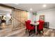 Dining area featuring a sliding barn door, wooden table with red chairs, and luxury vinyl flooring at 3018 Bradshaw Club Dr, Woodstock, GA 30188
