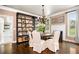 Cozy dining room with hardwood floors, natural light, decorative chandelier, and adjacent fireplace at 3018 Bradshaw Club Dr, Woodstock, GA 30188