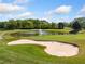 Scenic golf course view featuring a tranquil pond, sand traps, and manicured greens at 3018 Bradshaw Club Dr, Woodstock, GA 30188