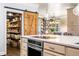 Open kitchen view with a large pantry, barn door, white countertop island with oven, and hanging lights at 3018 Bradshaw Club Dr, Woodstock, GA 30188