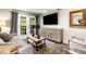 Cozy living room features french doors, a television, neutral walls, and modern decor at 3018 Bradshaw Club Dr, Woodstock, GA 30188