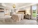 Elegant main bedroom featuring plush carpet, tray ceiling, and windows overlooking the backyard at 3018 Bradshaw Club Dr, Woodstock, GA 30188