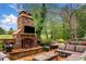 Beautiful stone outdoor fireplace with seating and manicured landscaping at 3018 Bradshaw Club Dr, Woodstock, GA 30188