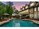 Backyard pool with outdoor seating and manicured landscaping at dusk at 3018 Bradshaw Club Dr, Woodstock, GA 30188