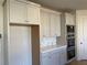 Modern kitchen features custom cabinets, stainless steel double ovens, and hexagon tile backsplash at 3063 Reserve Ct Sw, Conyers, GA 30094