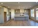 Open-concept kitchen with gray cabinets, large island, stainless steel appliances and hardwood floors at 3063 Reserve Ct Sw, Conyers, GA 30094