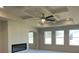 Modern living room with tray ceilings, a ceiling fan, a fireplace, and bright windows at 3063 Reserve Ct Sw, Conyers, GA 30094
