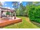Inviting backyard with a gazebo-covered deck, lush lawn, and mature trees at 5147 Winding Glen Dr, Lithonia, GA 30038