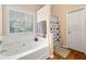 Cozy bathroom featuring a soaking tub, tiled walls, window, and modern fixtures at 5147 Winding Glen Dr, Lithonia, GA 30038