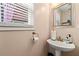Cozy bathroom featuring a pedestal sink, stylish mirror, and window at 5147 Winding Glen Dr, Lithonia, GA 30038