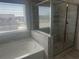 Bright bathroom with a soaking tub and a glass-enclosed shower with tiled walls at 157 Longhorn Way, Auburn, GA 30102
