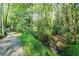 Idyllic backyard features a stream alongside a concrete walkway lined with lush greenery at 4554 Meadow Valley Dr, Atlanta, GA 30342