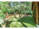 Artificial turf patio features a beautiful stone retaining wall and lush landscaping with mature trees at 4554 Meadow Valley Dr, Atlanta, GA 30342