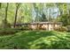 Charming brick home featuring a lush green lawn, mature trees and manicured landscaping at 4554 Meadow Valley Dr, Atlanta, GA 30342