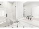 Modern bathroom with a glass shower, marble-look tile, dual-flush toilet, and vanity with black hardware at 490 Hammons Way, Atlanta, GA 30315