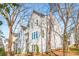 Three-story home featuring neutral siding, large windows, and a landscaped yard at 490 Hammons Way, Atlanta, GA 30315