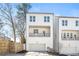 Modern three-story home with a covered porch, two-car garage, and neutral-colored siding at 490 Hammons Way, Atlanta, GA 30315