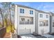 Modern three-story home with a covered porch, two-car garage, and neutral-colored siding at 490 Hammons Way, Atlanta, GA 30315