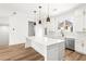 Modern kitchen with a large island, white cabinets, stainless steel appliances, and stylish pendant lighting at 490 Hammons Way, Atlanta, GA 30315