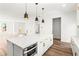 Modern kitchen with a large island, white cabinets, stainless steel appliances and pendant lighting at 490 Hammons Way, Atlanta, GA 30315