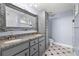 Bathroom featuring dual sinks, granite countertop, ornate framed mirror and decorative floors at 1500 Tara Pl # 810, Hampton, GA 30228