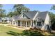 Attractive home with a covered porch, stone accents, and lush lawn surrounded by mature trees at 31 Cedar Gate Ln, Kingston, GA 30145