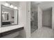 Bright bathroom with glass enclosed shower, makeup vanity, gray toned floors and fixtures at 705 Abbington River Ln, Atlanta, GA 30339