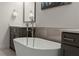 Close up of bright bathroom featuring vanity, soaking tub, faucet and neutral-toned backsplash at 705 Abbington River Ln, Atlanta, GA 30339