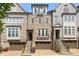 Charming townhome with stone facade, brown garage door, and stairs leading to front door at 705 Abbington River Ln, Atlanta, GA 30339