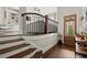 Bright foyer with hardwood floors, staircase, wood railing, and open view to the living area at 705 Abbington River Ln, Atlanta, GA 30339