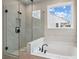 Bright bathroom boasts a soaking tub and a separate glass-enclosed shower with elegant marble-look tile at 719 Crossroad Ct, Powder Springs, GA 30127
