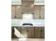 Close-up of the well-lit kitchen with wooden cabinets, gas stove and white subway tile backsplash at 719 Crossroad Ct, Powder Springs, GA 30127