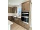 Modern kitchen with stainless steel appliances, stone countertops, and dark wood cabinets at 719 Crossroad Ct, Powder Springs, GA 30127